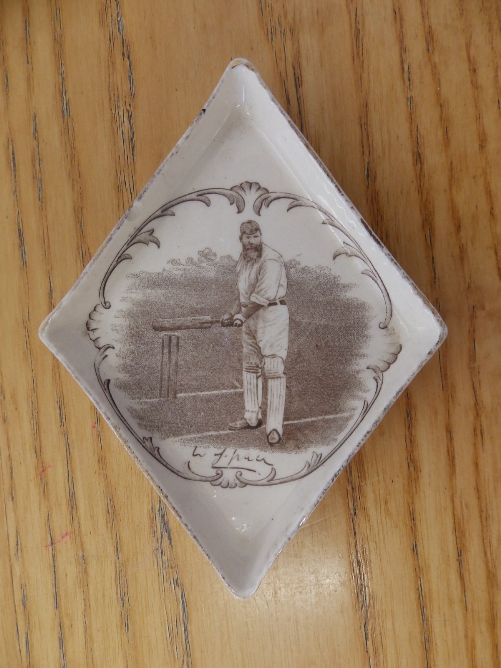 A small Macintyre lozenge shaped dish printed with a portrait of W. G. Grace.