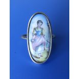 An oval yellow metal ring set with an oval enamelled porcelain panel depicting a young female in