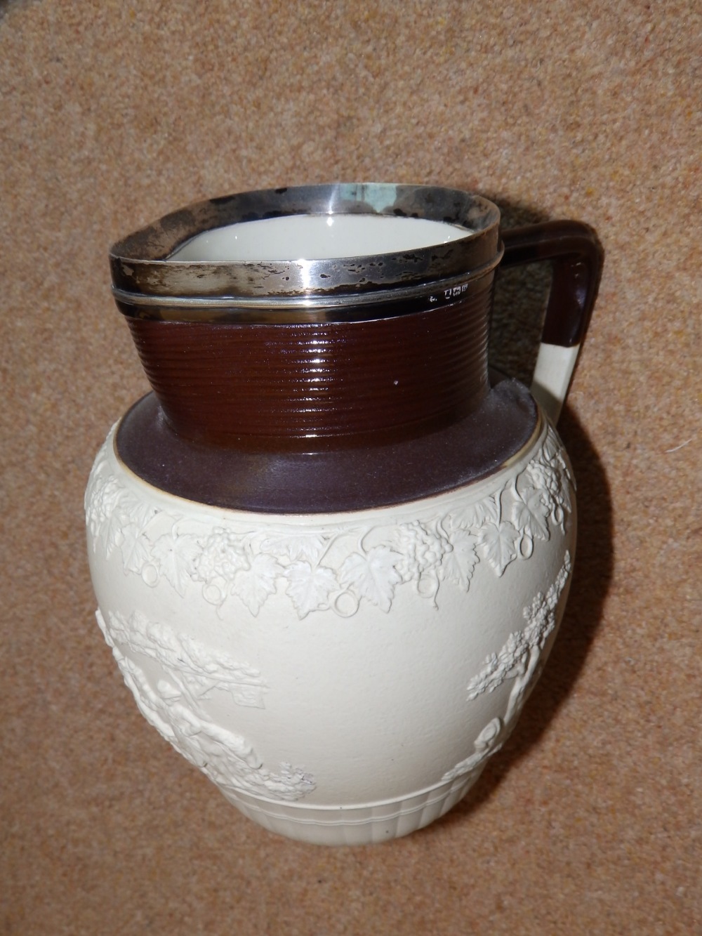 A silver-rimmed white moulded ware jug by Turner – star crack to body.