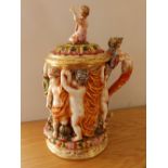 A Naples porcelain tankard decorated in high relief with cavorting putti.
