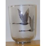 A glass vase decorated in silver lustre to depict geese in flight, 8.5” high.