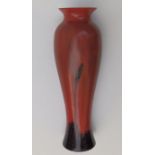 An early 20thC art glass vase in red with black inner casing to rim, the lower portion decorated