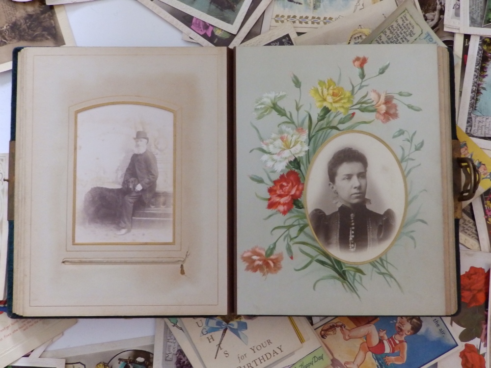 An early 20thC family photo album together with approximately 50 loose postcards and greeting