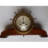 An American brass ship's striking clock by Waterbury of ship's wheel form, with 4” dial, sitting