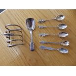A small Birmnigham silver toast rack, an 1836 silver spoon – London, and five small souvenir spoons.