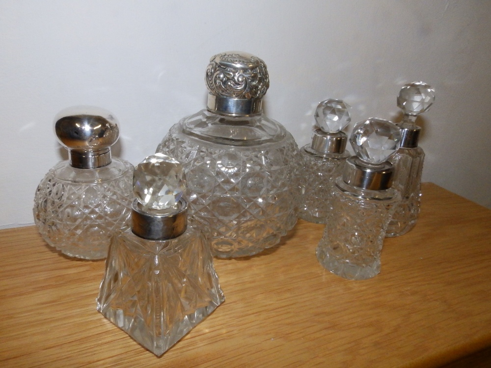 A London silver mounted cut glass scent bottle and five others. (6)