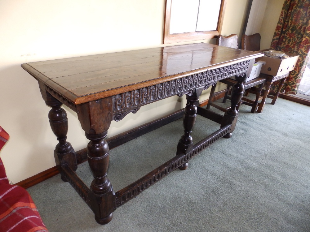 An oak side table with carved frieze, standing on six legs united by low stretchers, Height 32”,