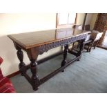 An oak side table with carved frieze, standing on six legs united by low stretchers, Height 32”,