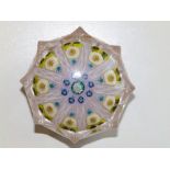 A paperweight of fluted facet form, the millefiori canes interspersed with latticinio on a