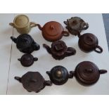 A collection of 10 Chinese pottery teapots.