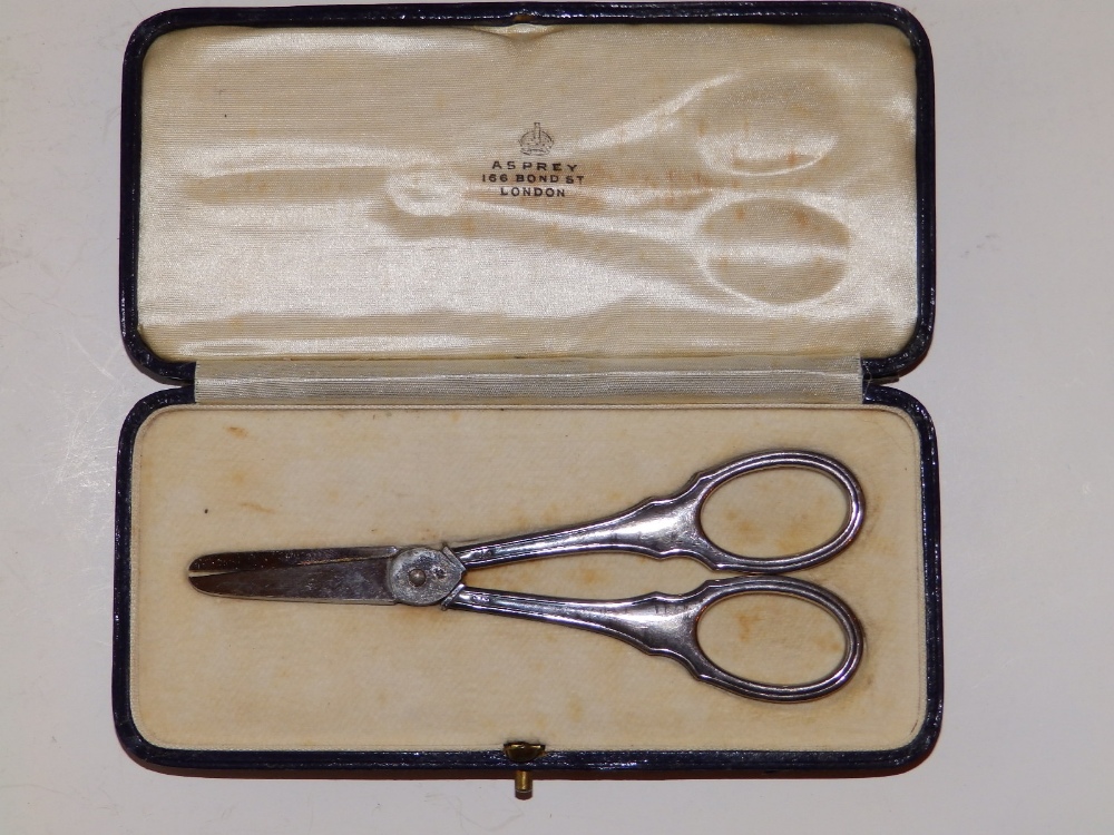 A small pair of plain 925 metal grape scissors in Asprey case.