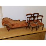 A Victorian doll's house chaise longue, 11” across and four dining chairs. (5)