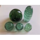 Five Victorian green glass 'dump' paperweights, the largest 7” high.
