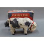 A Blue Ribbon Brand "Furious Bull" wind up toy, having simulated fur and wooden hoofs,