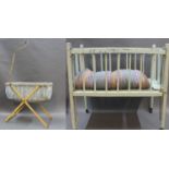 A lime green painted wooden doll's cot raised on castors, measuring 47cm high by 61cm long,