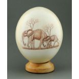 An engraved ostrich egg, depicting an African elephant and its calf, signed "Rodger Ndlovu",