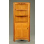 A Reynolds of Ludlow oak standing corner cupboard, with open shelves above a panelled cupboard door.