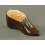 A carved leather pin cushion, early 19th century, modelled in the shape of a ladies shoe,