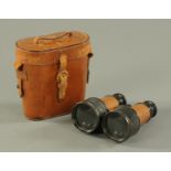 A pair of Great War period leather cased field glasses, with tan leather grips, stamped "x 5 27/16",