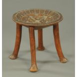 An African tribal stool, circular, raised on four legs with pad feet. Diameter 40 cm.