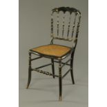 A late 19th century ebonised musical chair, with Bergere seat and musical movement playing two airs,