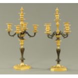 A pair of brass and metal four branch candelabra, each raised on an octagonal base.