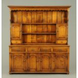 An oak dresser with Delft rack, fitted with a series of shelves, cupboards and drawers,