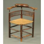 A 19th century corner rush seated armchair with turned legs and stretchers.