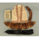 Four fur stoles, and an embroidered waistcoat, all early 20th century.