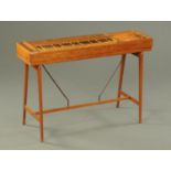 A burr walnut and oak spinet, raised on angled legs with stretchers and in the Arts & Crafts style.