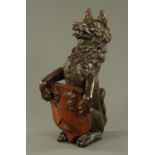 A carved oak heraldic beast, late 19th/early 20th century, carved as a wolf seated on its haunches,