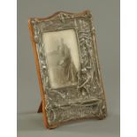 An Edwardian silver plated embossed photograph frame, circa 1905, decorated with a scene from H.W.