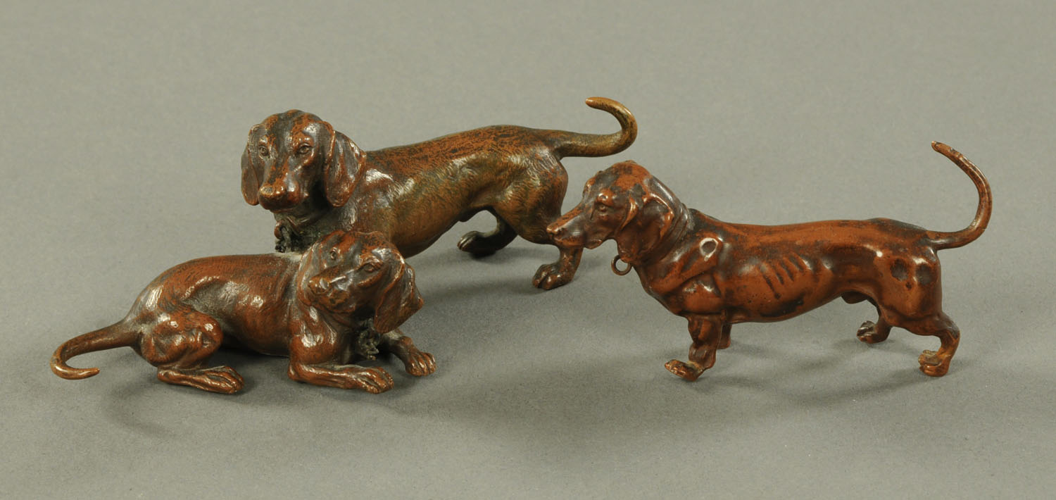 After Franz Bergman, a patinated bronze group of two dachshunds and a single standing dachshund,