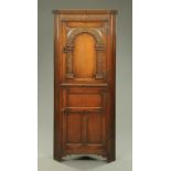 A Titchmarsh & Goodwin style standing oak corner cupboard, with arched upper door. Width 77 cm.