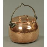 A 19th century copper cooking vessel, with lid and iron loop handle.