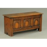 An oak coffer, reproduction, with guilloche frieze, three arched panels and raised on stile feet.