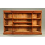 An Edwardian breakfront walnut low bookcase, with adjustable shelves and plinth base. Width 175.