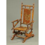A late Victorian child's American rocking chair, typical form, with upholstered back and seat.