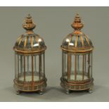 A pair of metal and glazed lanterns, each with carrying handle, pierced base and short feet.