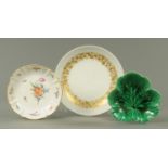 A Rosenthal plaque, Nymphenburg polychrome dish and cabbage leaf plate. Largest diameter 31 cm.