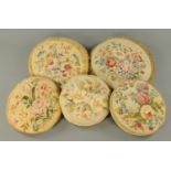 Five circular squab cushions, 19th/20th century, each with a hand stitched tapestry floral panel.