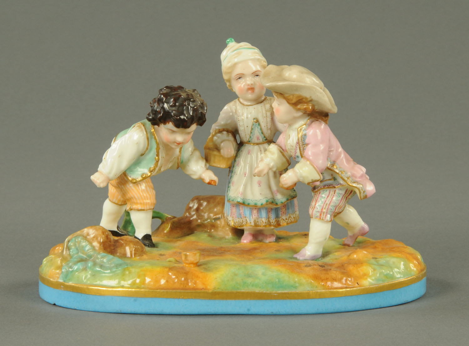 A Meissen style figure group, children playing, crossed swords mark to base. Length 18 cm.