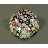 A late 19th century paperweight, set with variegated and coloured canes. Diameter 7 cm, height 5.