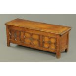 An oak coffer, with lift up top, three panelled carved front and raised on stile feet.