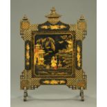 An Edwardian black lacquered Chinoiserie fire screen. Width 86 cm (see illustration).