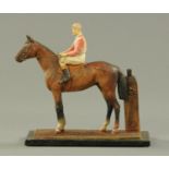 A spelter painted horse and jockey table lighter, raised on a rectangular glass base. Length 17.