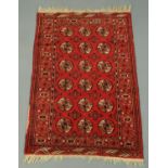 A Persian design woollen rug, with centre rectangular panel, multiple line border and fringed ends,