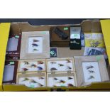 A box of 2 wooden fly boxes with salmon flies, 2 hip flasks, 2 framed flies, brooches, etc.