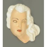 An Art Deco style pottery wall mask, mid 20th century, modelled with a bisque base,