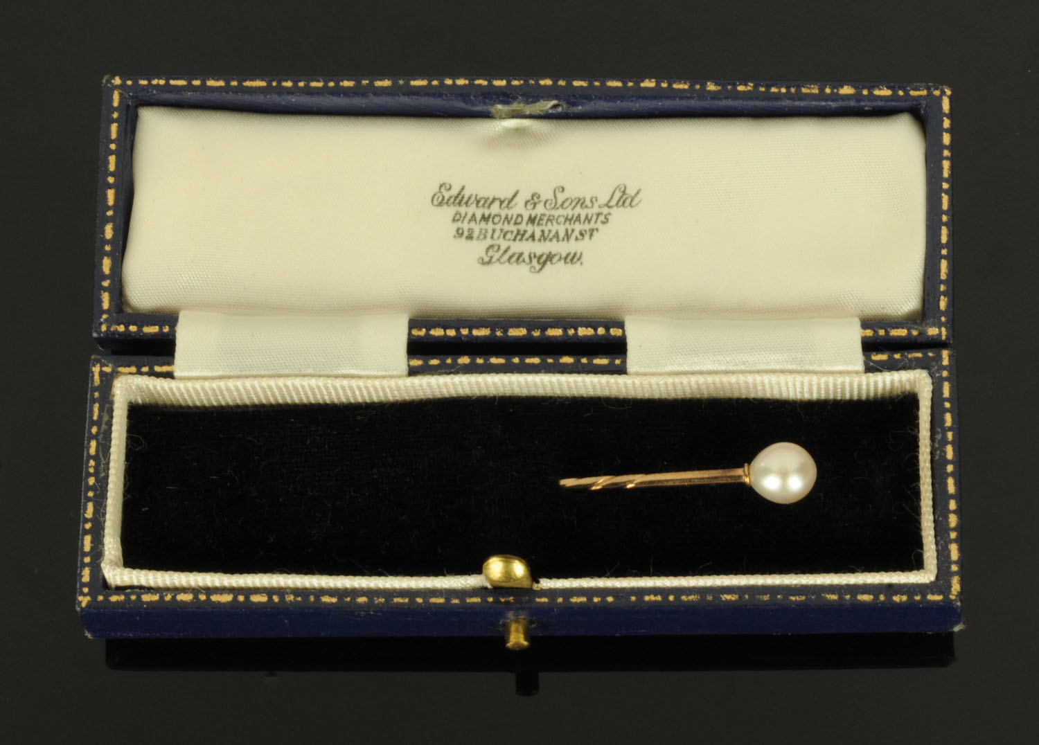 A gold coloured metal stick pin, with pearl terminal, cased.